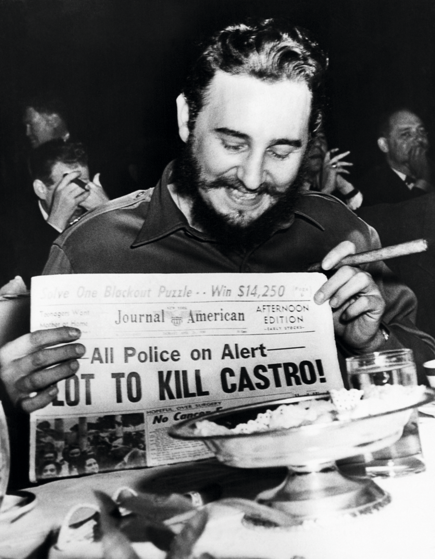 Фидель Кастро держит газету с рассказом о заговоре с целью убить.png